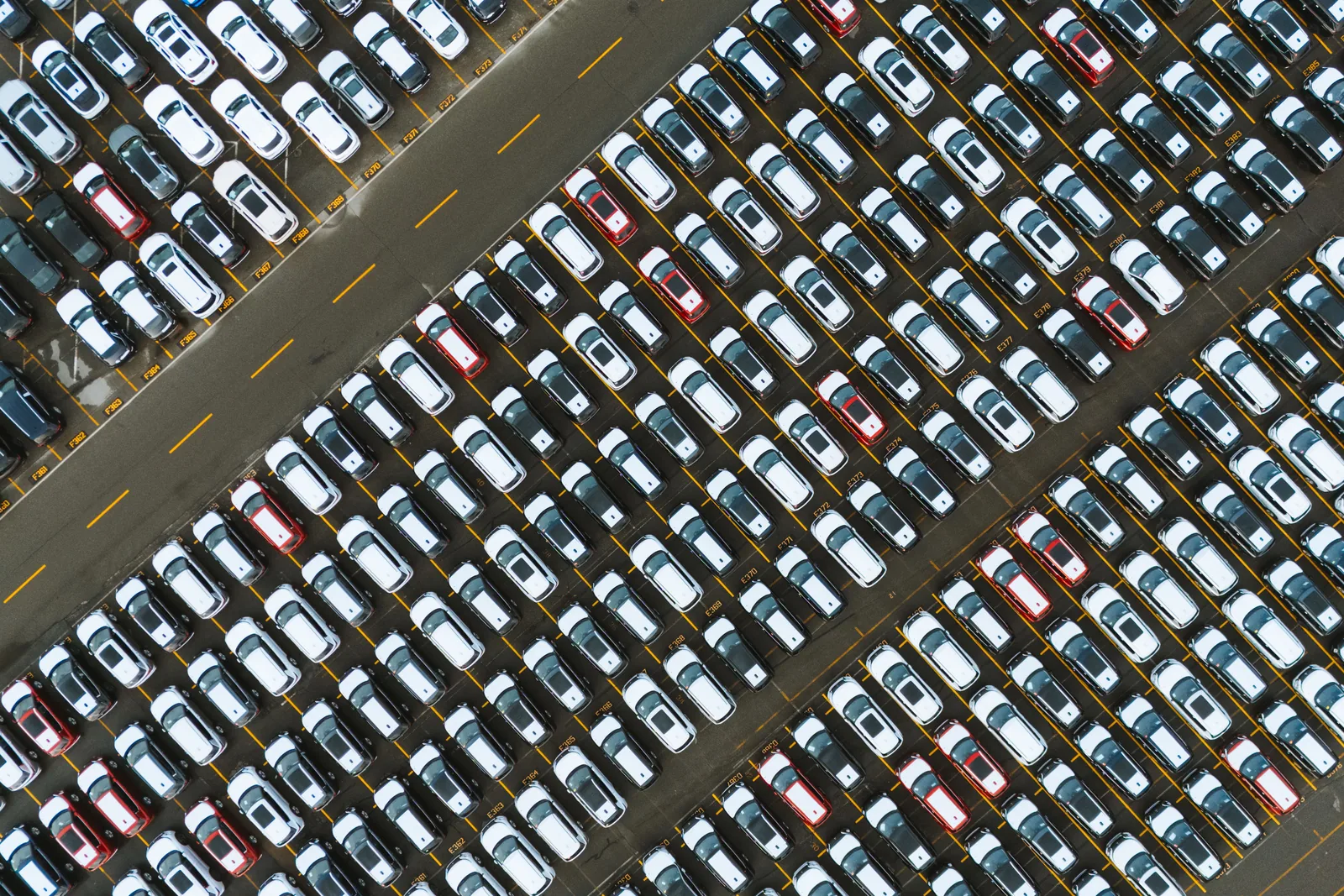 Rijen geparkeerde personenwagens, recht van boven gefotografeerd.